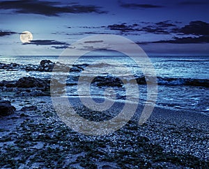 Sea shore with stones after the storm at night